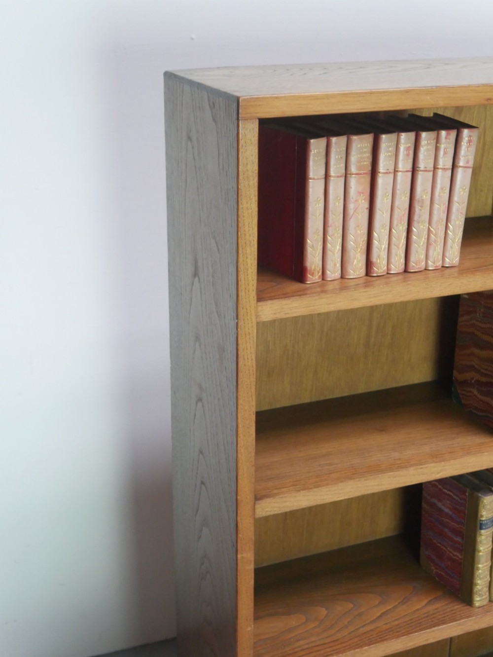 A wide, low Arts and Crafts oak bookcase featuring double open bays with multiple horizontal shelves. View VIII
