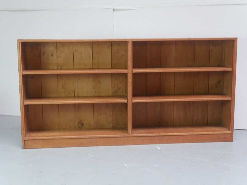 A wide, low Arts and Crafts oak bookcase featuring double open bays with multiple horizontal shelves. View IX