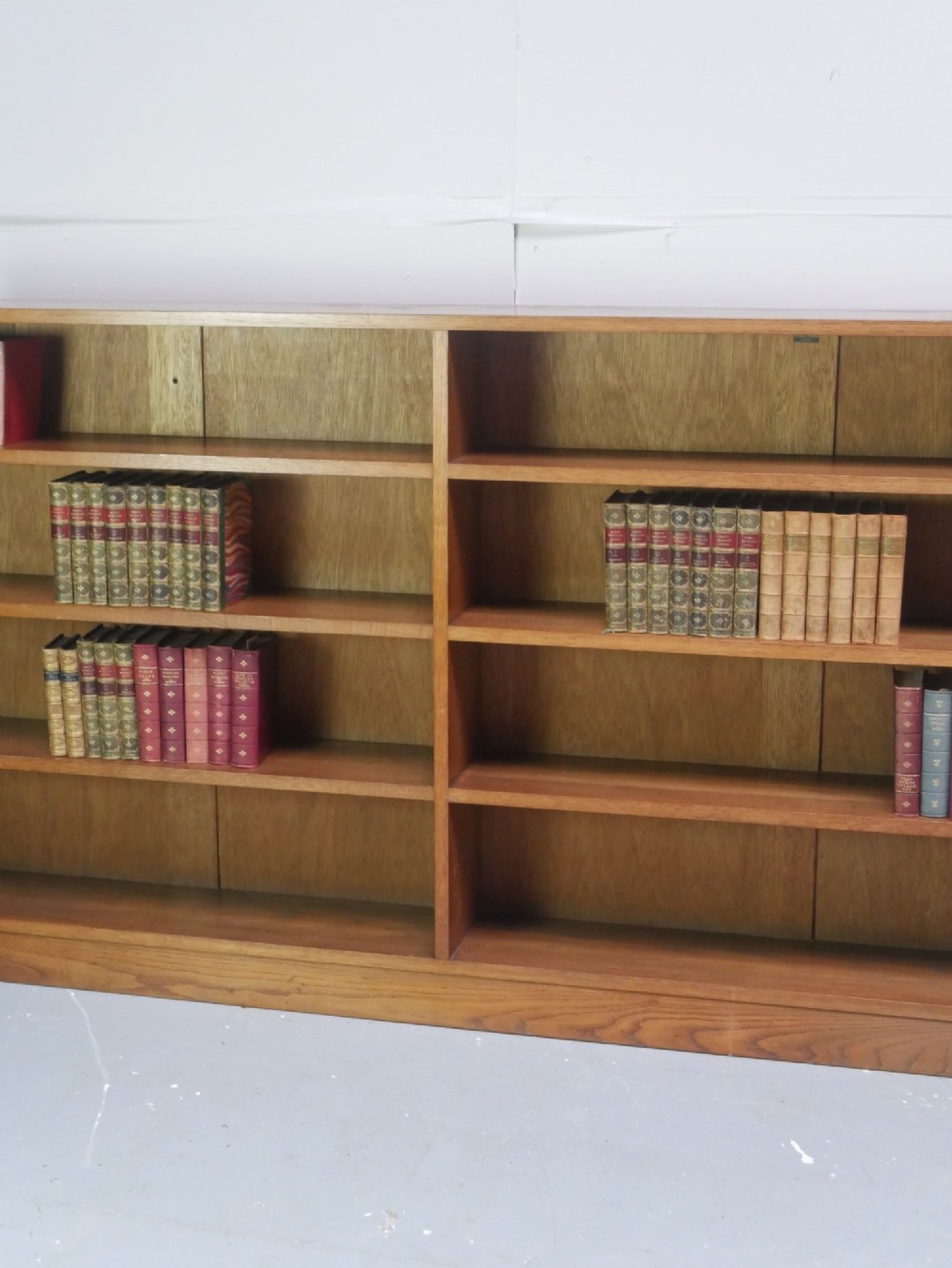 A wide, low Arts and Crafts oak bookcase featuring double open bays with multiple horizontal shelves. View XI