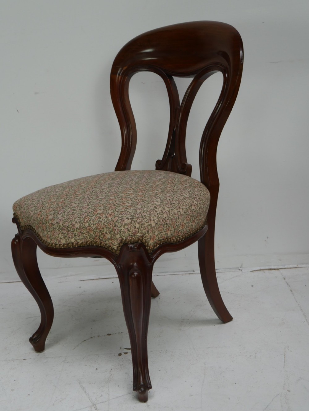 A set of four 19th-century mahogany dining chairs with carved open backs, upholstered seats, and cabriole legs. View II
