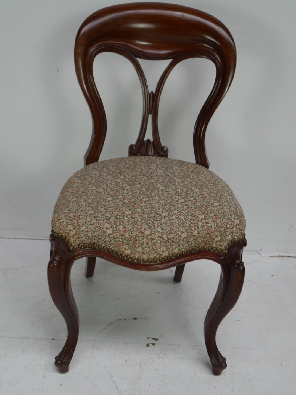 A set of four 19th-century mahogany dining chairs with carved open backs, upholstered seats, and cabriole legs. View IV