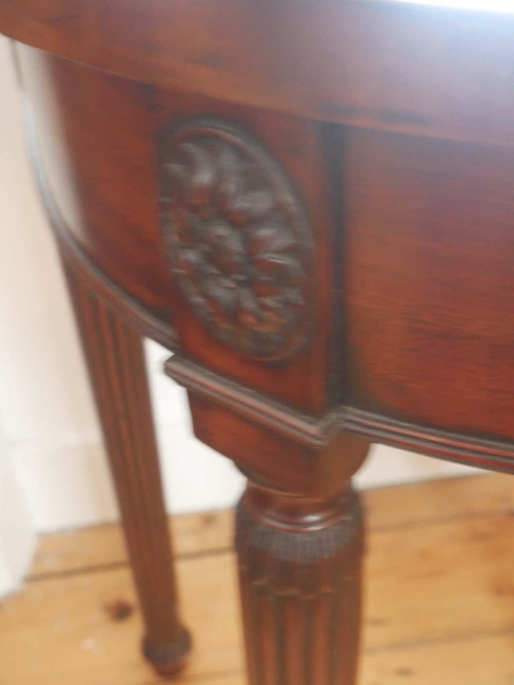 An English 19th-century demilune console table with hand-painted floral swags across the curved apron and slender tapered square legs. View IX