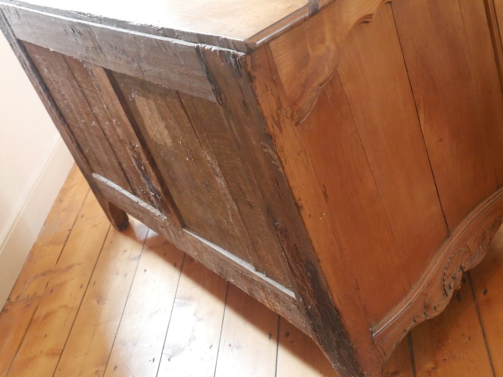 An eighteenth-century French provincial walnut commode featuring three drawers with brass handles, a carved apron, and short cabriole legs. View XIII