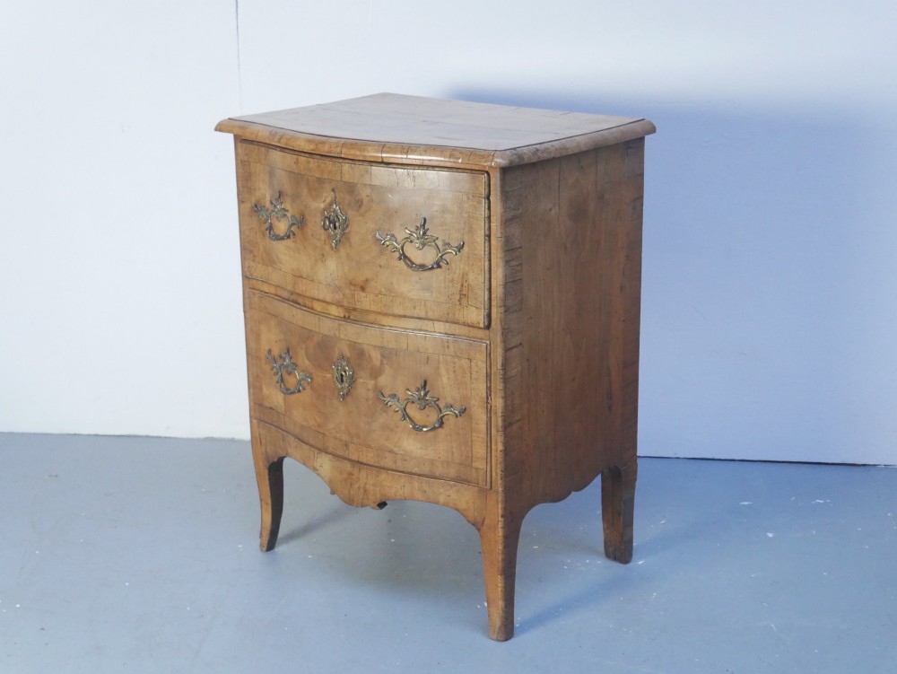 An 18th-century Swedish wooden commode featuring two bow-fronted drawers, ornamental brass handles, escutcheons, and curved lower legs. View II