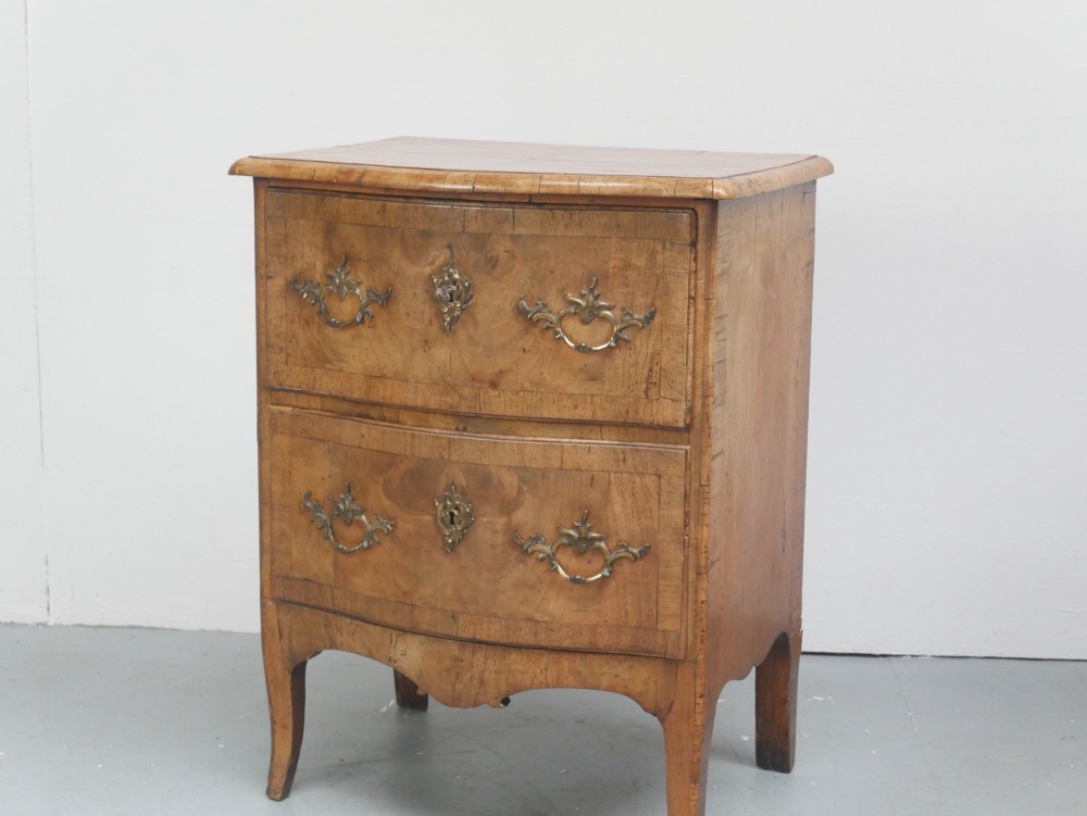 An 18th-century Swedish wooden commode featuring two bow-fronted drawers, ornamental brass handles, escutcheons, and curved lower legs. View VIII
