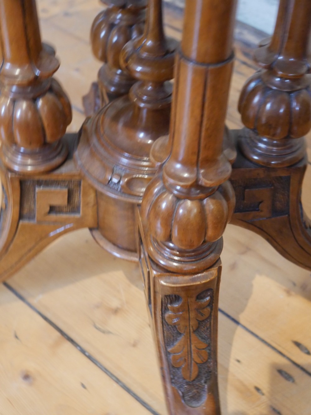 A 19th-century Irish walnut fold-over games table with a scalloped carved apron, turned twin pedestal supports, and carved splayed legs on white castors. View VIII