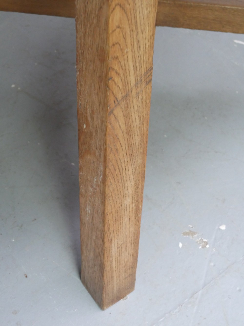 A circular solid oak centre table featuring splayed square legs connected by a central cross-stretcher. View IV