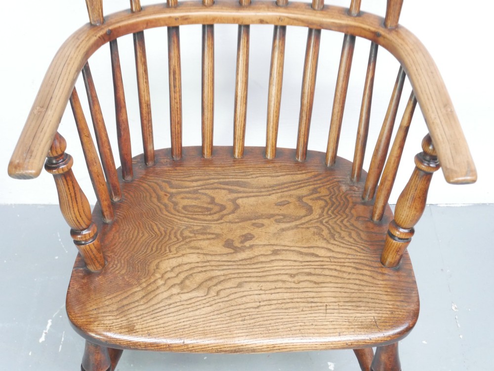 A warm brown wooden Scottish Windsor armchair featuring a hoop back with vertical spindles, shaped saddle seat, and turned legs. View II