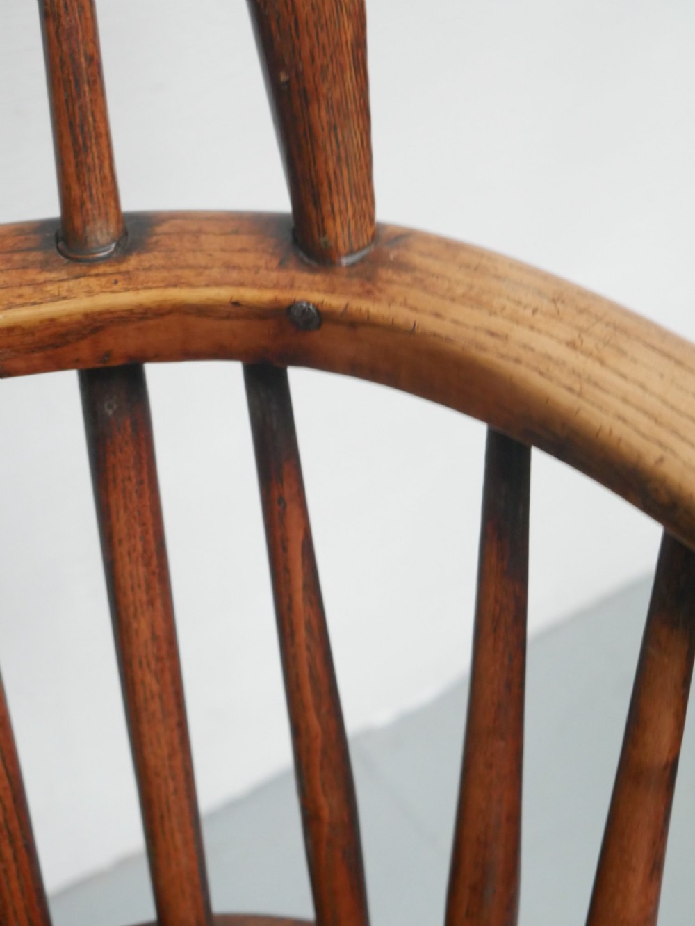 A warm brown wooden Scottish Windsor armchair featuring a hoop back with vertical spindles, shaped saddle seat, and turned legs. View VI