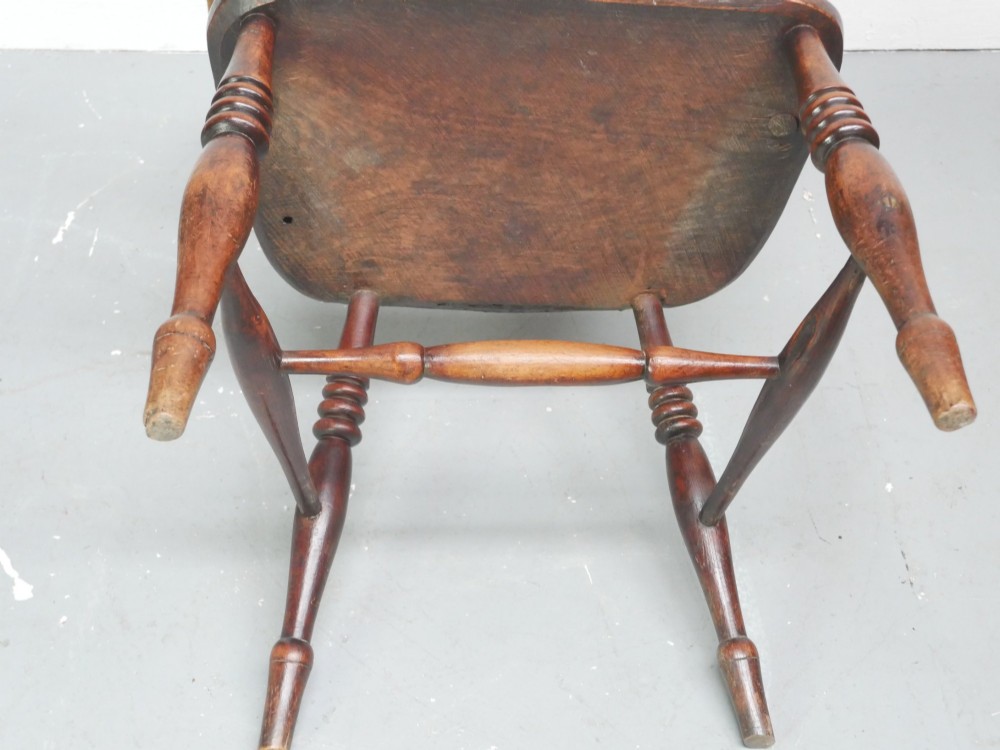 A warm brown wooden Scottish Windsor armchair featuring a hoop back with vertical spindles, shaped saddle seat, and turned legs. View X