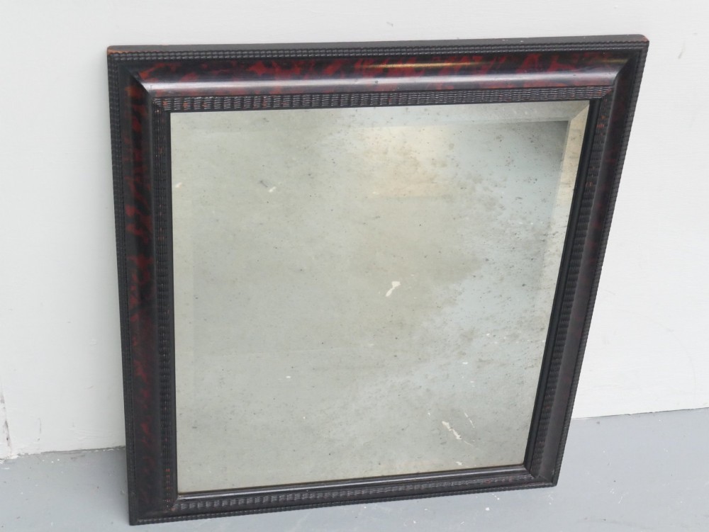 A rectangular wall mirror with a dark red and black mottled faux tortoiseshell frame featuring beaded inner moulding. View VI