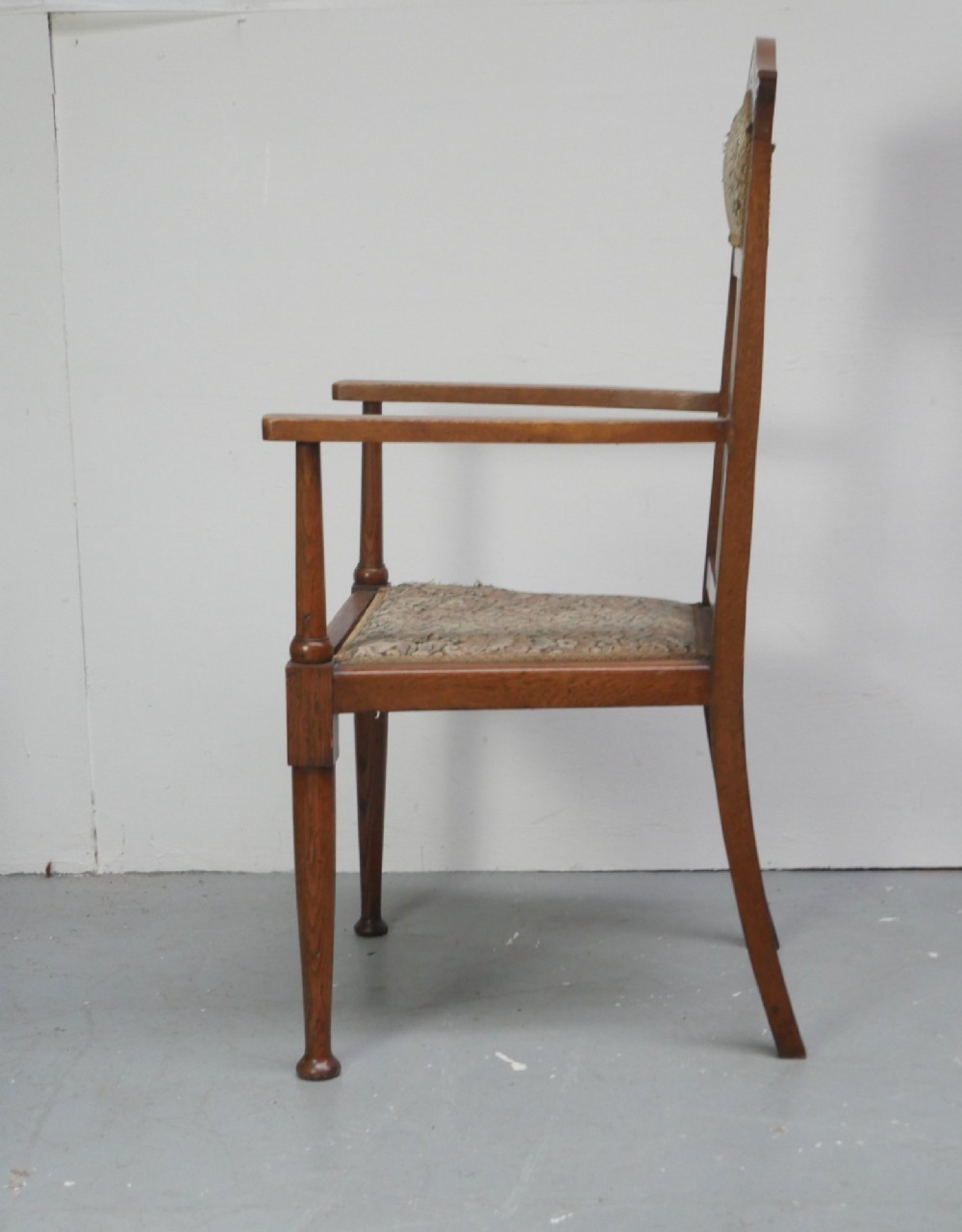 An antique oak armchair featuring a carved top rail, tapestry fabric back panel and seat, and a pierced decorative back splat. View III