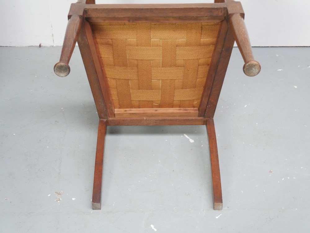 An antique oak armchair featuring a carved top rail, tapestry fabric back panel and seat, and a pierced decorative back splat. View VIII
