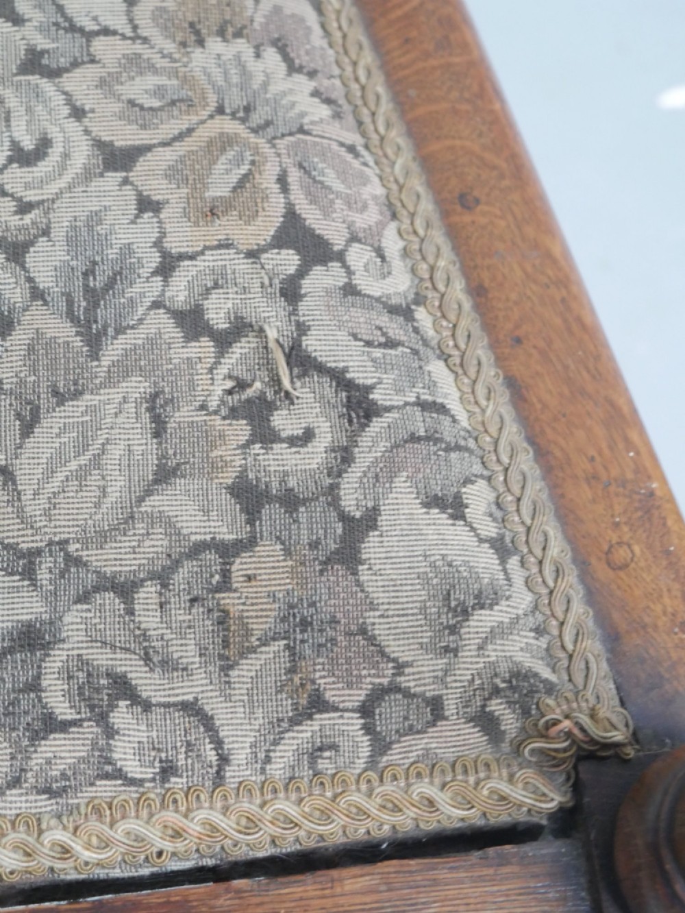 An antique oak armchair featuring a carved top rail, tapestry fabric back panel and seat, and a pierced decorative back splat. View X