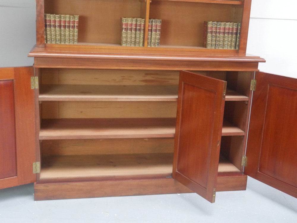 A large nineteenth-century mahogany bookcase featuring open upper shelving and a lower cupboard with three arched panel doors. View III