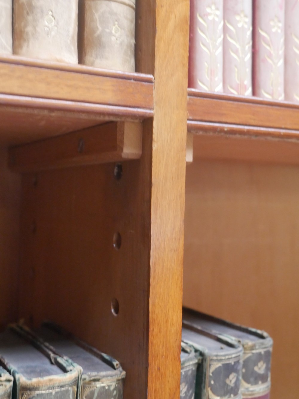 A large nineteenth-century mahogany bookcase featuring open upper shelving and a lower cupboard with three arched panel doors. View VI