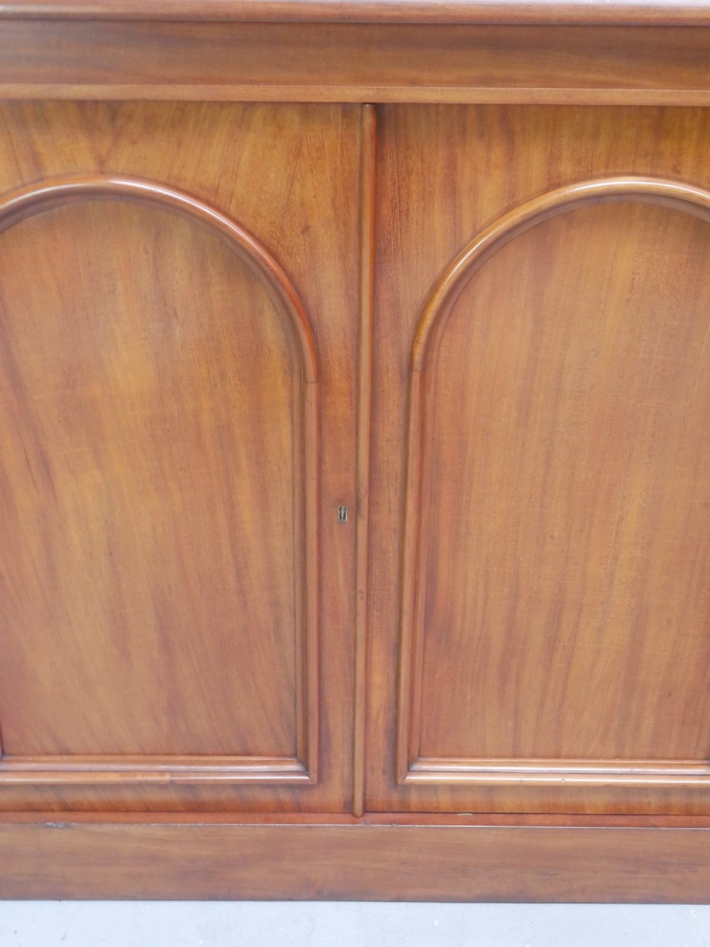 A large nineteenth-century mahogany bookcase featuring open upper shelving and a lower cupboard with three arched panel doors. View VIII