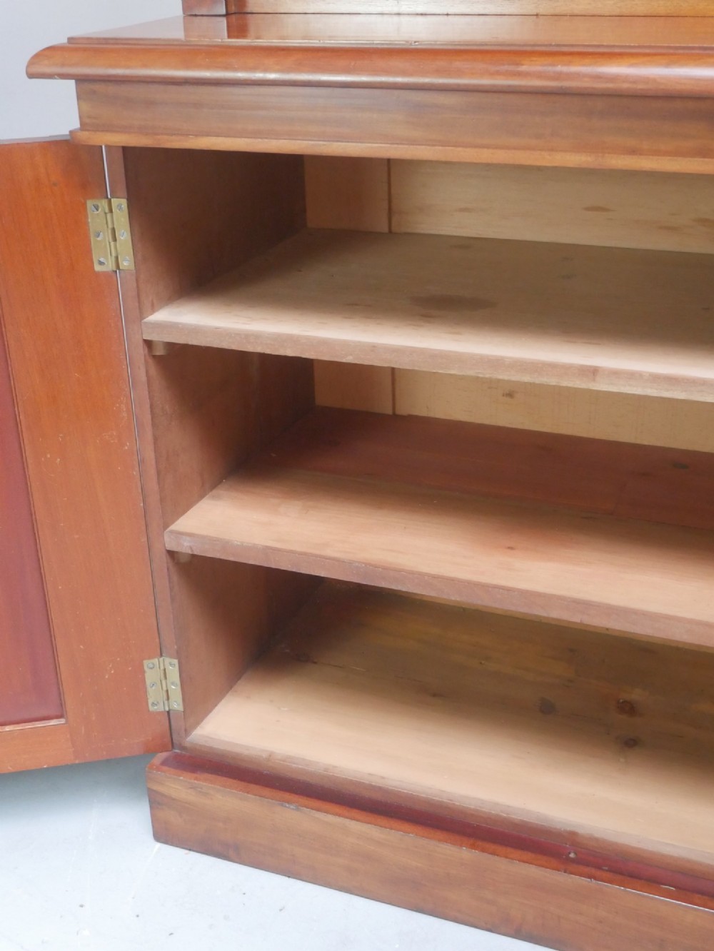 A large nineteenth-century mahogany bookcase featuring open upper shelving and a lower cupboard with three arched panel doors. View X