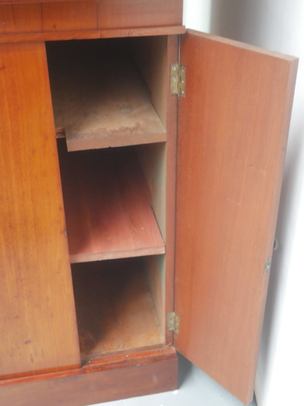 A large nineteenth-century mahogany bookcase featuring open upper shelving and a lower cupboard with three arched panel doors. View XI