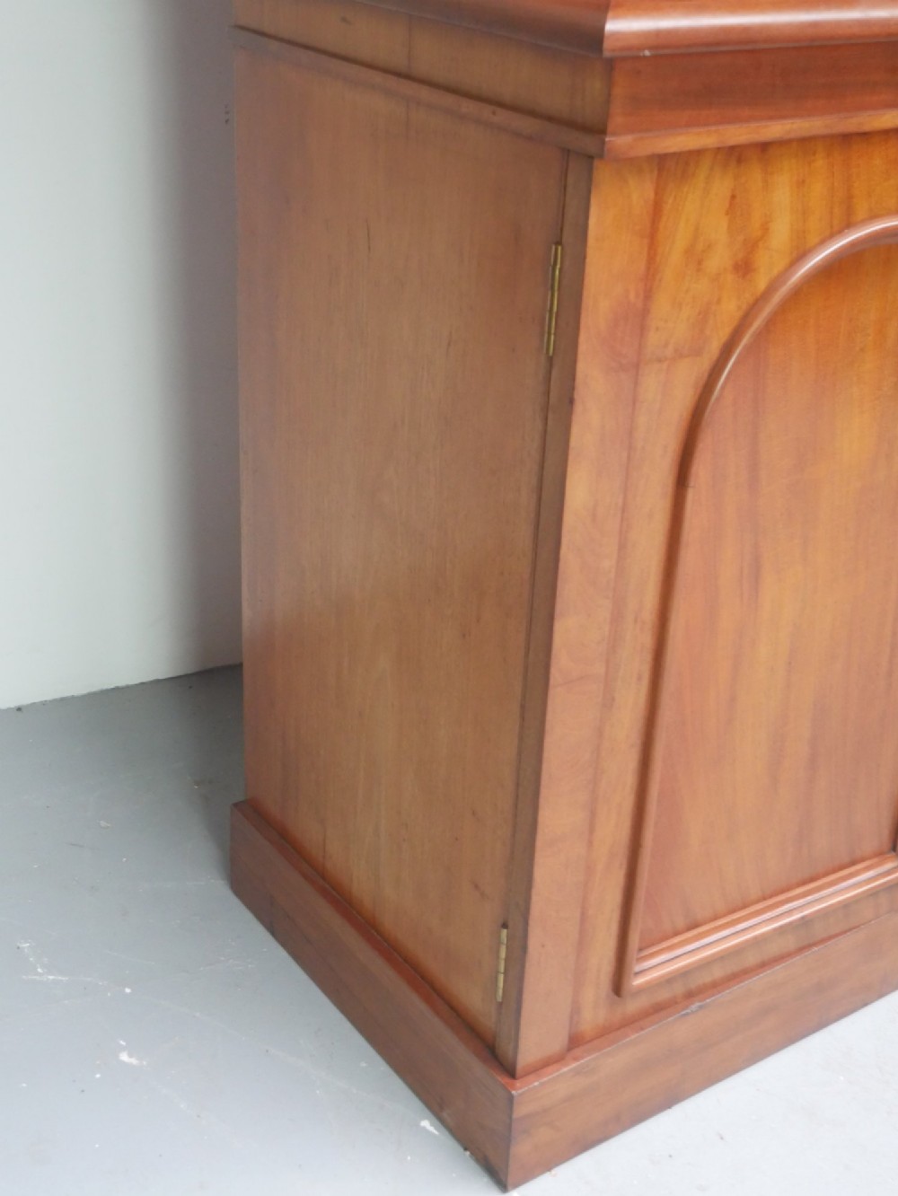 A large nineteenth-century mahogany bookcase featuring open upper shelving and a lower cupboard with three arched panel doors. View XII