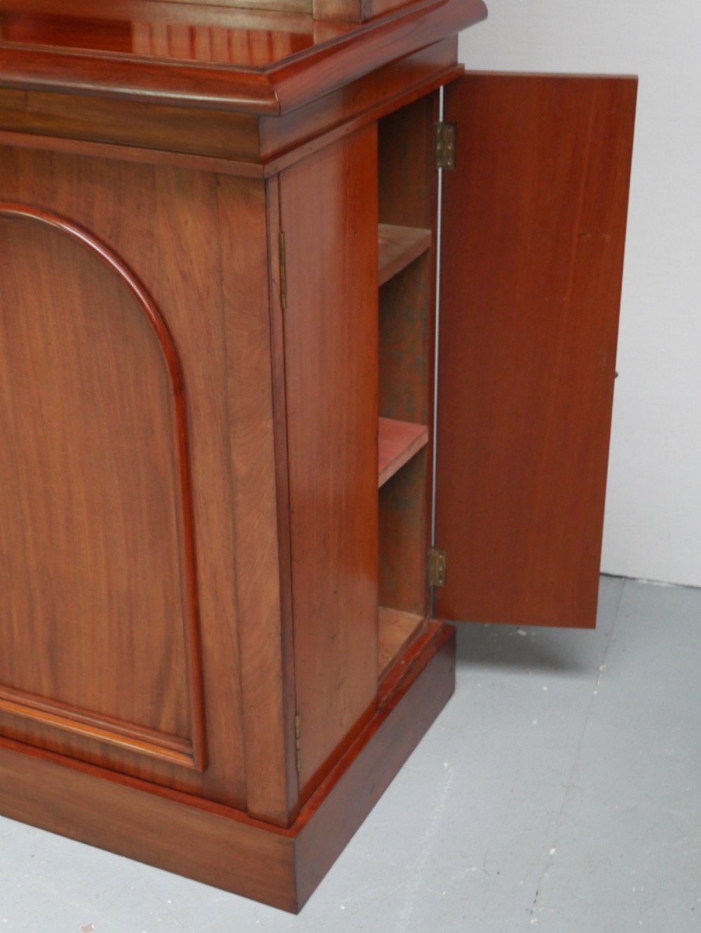 A large nineteenth-century mahogany bookcase featuring open upper shelving and a lower cupboard with three arched panel doors. View XIV