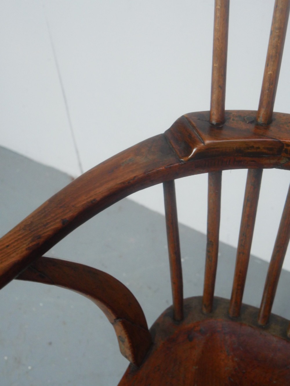 A mid-19th-century warm brown wooden Windsor armchair featuring a double-tier spindle back, carved saddle seat, curved armrests, and turned legs. View VI