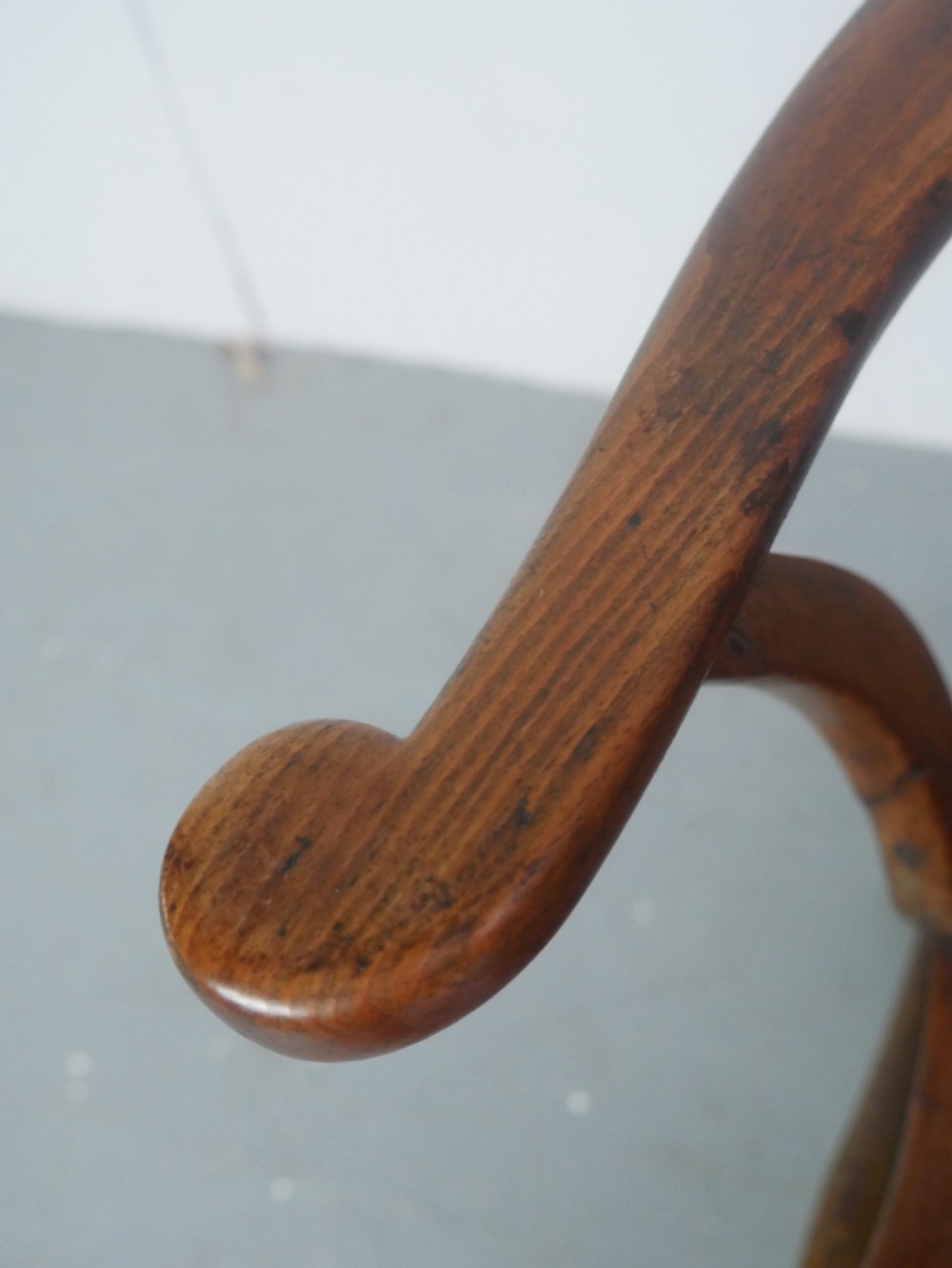 A mid-19th-century warm brown wooden Windsor armchair featuring a double-tier spindle back, carved saddle seat, curved armrests, and turned legs. View IX