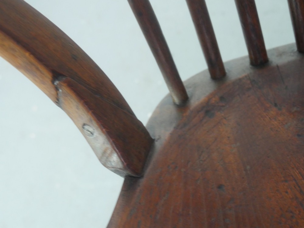 A mid-19th-century warm brown wooden Windsor armchair featuring a double-tier spindle back, carved saddle seat, curved armrests, and turned legs. View XI