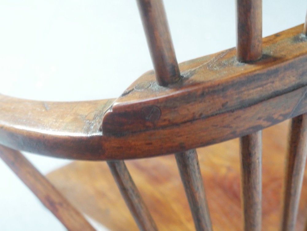 A mid-19th-century warm brown wooden Windsor armchair featuring a double-tier spindle back, carved saddle seat, curved armrests, and turned legs. View XIII