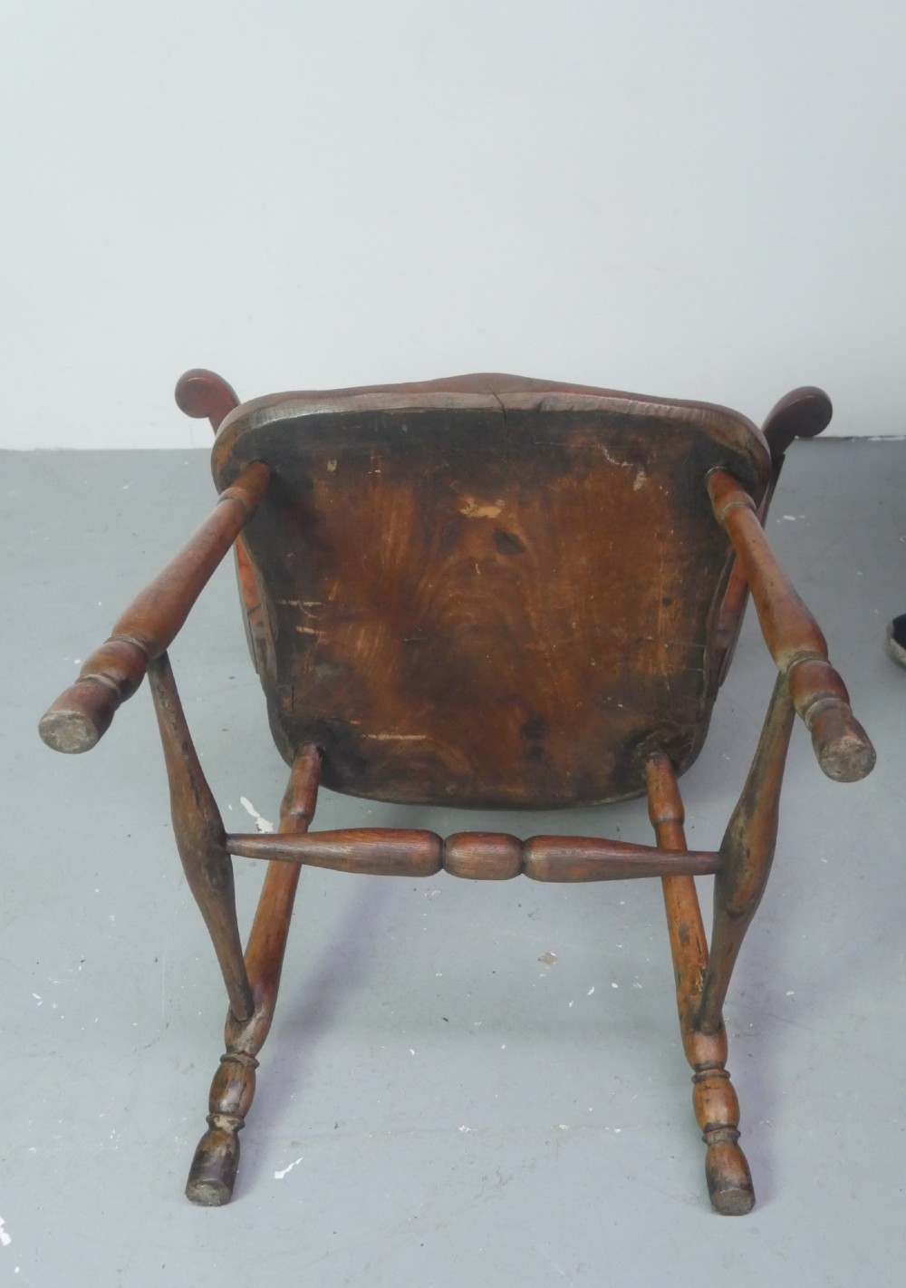 A mid-19th-century warm brown wooden Windsor armchair featuring a double-tier spindle back, carved saddle seat, curved armrests, and turned legs. View XIV