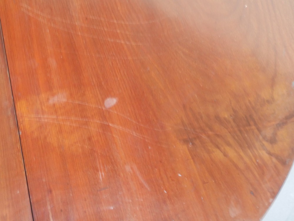 An antique mahogany drop-leaf dining table featuring reeded turned legs set on brass castors, displayed with both side leaves lowered. View VIII