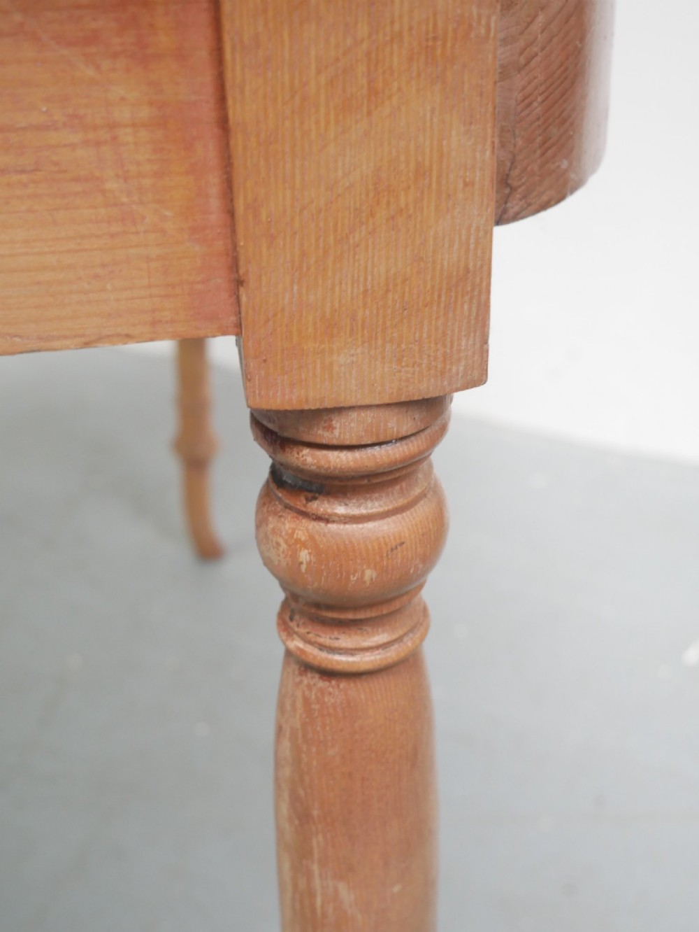 A Regency warm pine writing table featuring turned legs, a single central drawer with a brass knob, and a raised gallery upstand along the top. View XI