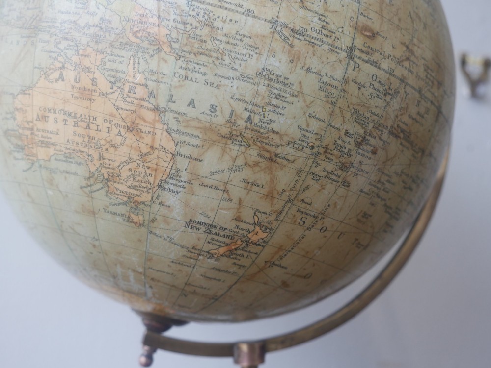 An antique terrestrial desk globe titled Philips British Empire Globe featuring cream paper gores mounted on a brass semi-meridian arm and an ebonised turned wooden base. View IV