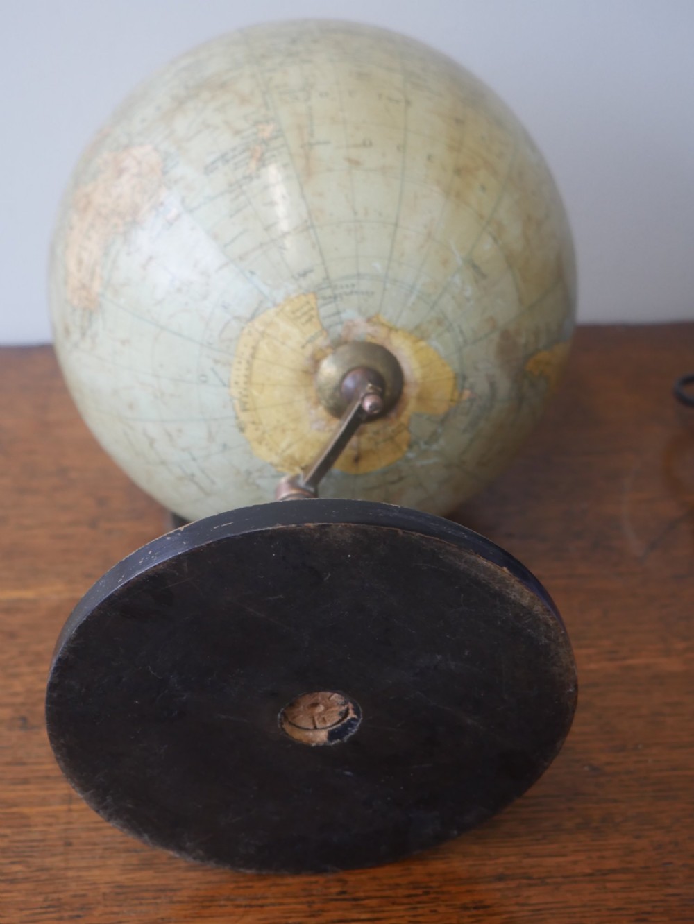 An antique terrestrial desk globe titled Philips British Empire Globe featuring cream paper gores mounted on a brass semi-meridian arm and an ebonised turned wooden base. View V