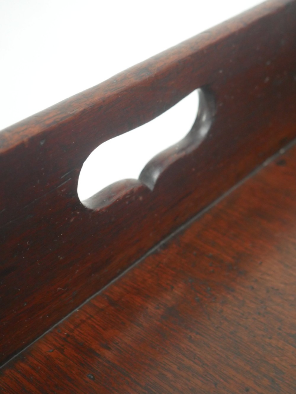 A dark mahogany butlers tray with integrated hand cutout handles resting on a matching folding x-frame stand. View III