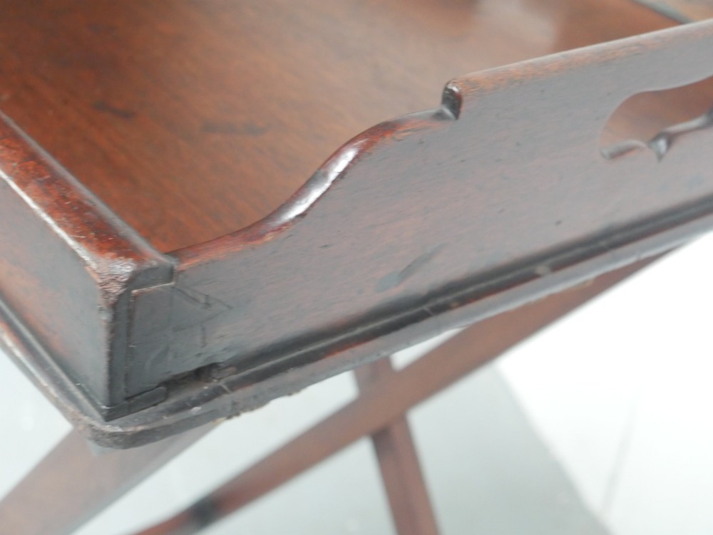 A dark mahogany butlers tray with integrated hand cutout handles resting on a matching folding x-frame stand. View VIII