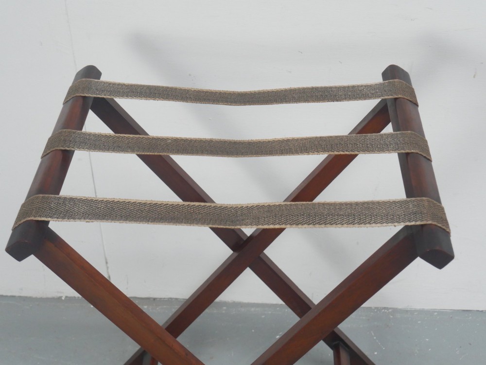 A dark mahogany butlers tray with integrated hand cutout handles resting on a matching folding x-frame stand. View X
