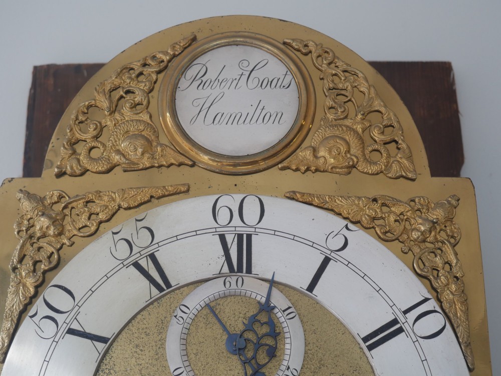 A tall Scottish mahogany longcase clock featuring a swan-neck pediment with brass finials, fretwork details, and an brass dial with silvered chapter ring. View IV