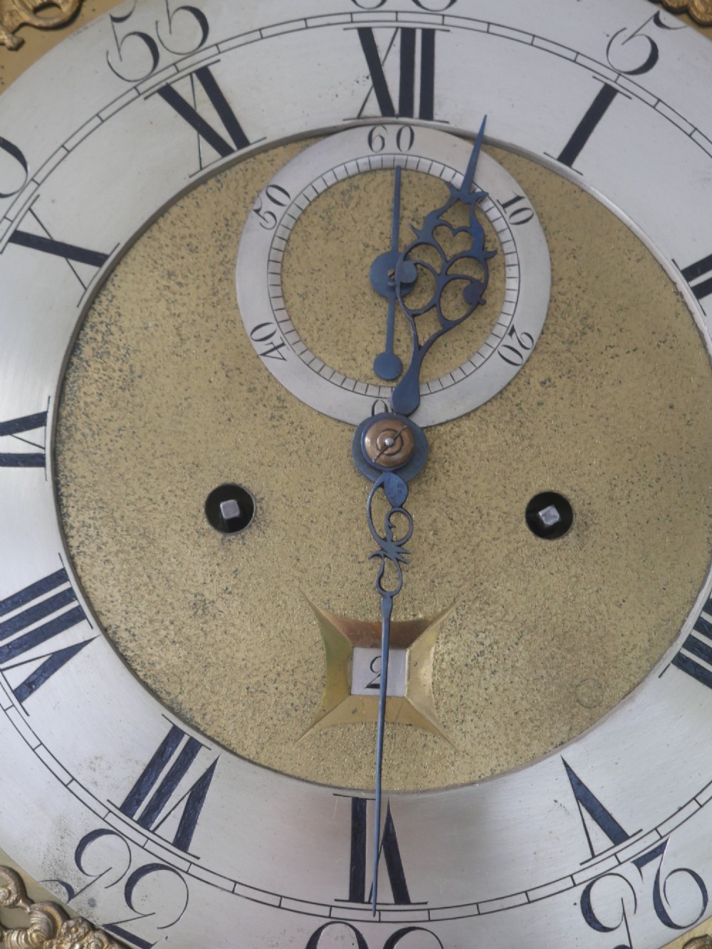 A tall Scottish mahogany longcase clock featuring a swan-neck pediment with brass finials, fretwork details, and an brass dial with silvered chapter ring. View V