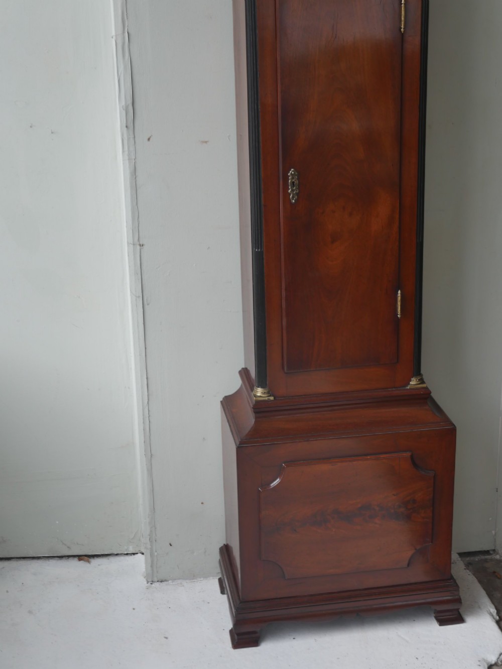 A tall Scottish mahogany longcase clock featuring a swan-neck pediment with brass finials, fretwork details, and an brass dial with silvered chapter ring. View XII