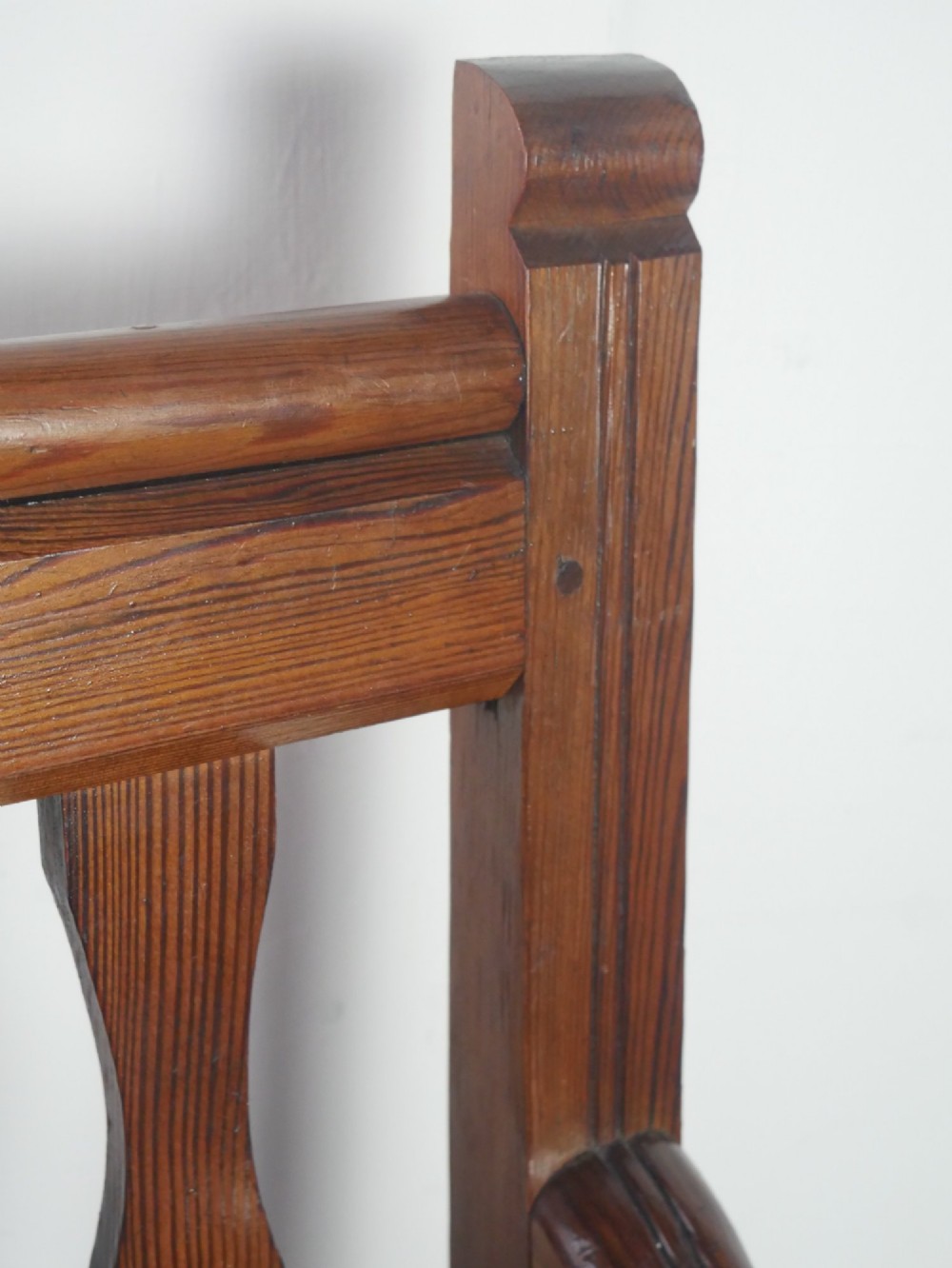 A warm brown pine hall bench featuring turned front legs, shaped back slats, swept armrests, and a solid timber seat. View III
