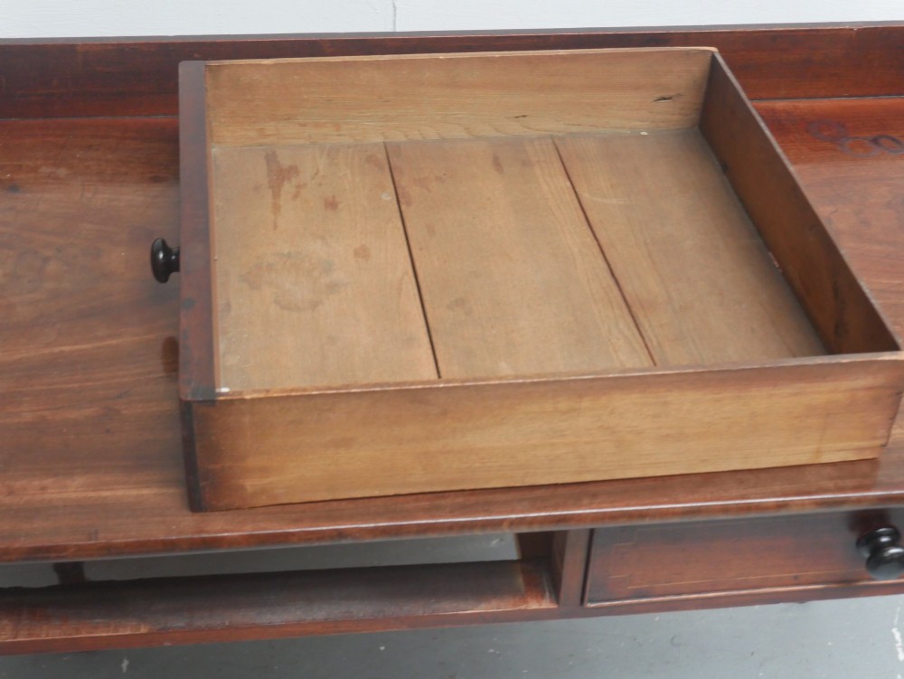 An antique Regency mahogany writing table featuring a raised gallery back, two frieze drawers with line inlay, and turned legs. View VII