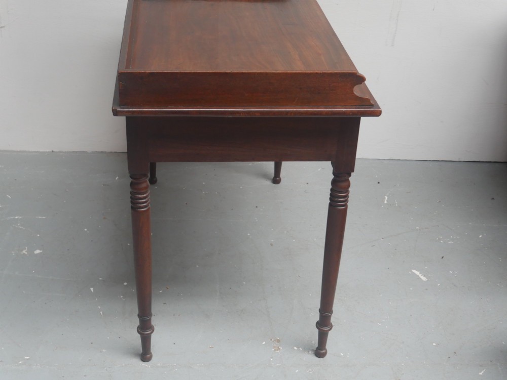 An antique Regency mahogany writing table featuring a raised gallery back, two frieze drawers with line inlay, and turned legs. View VIII