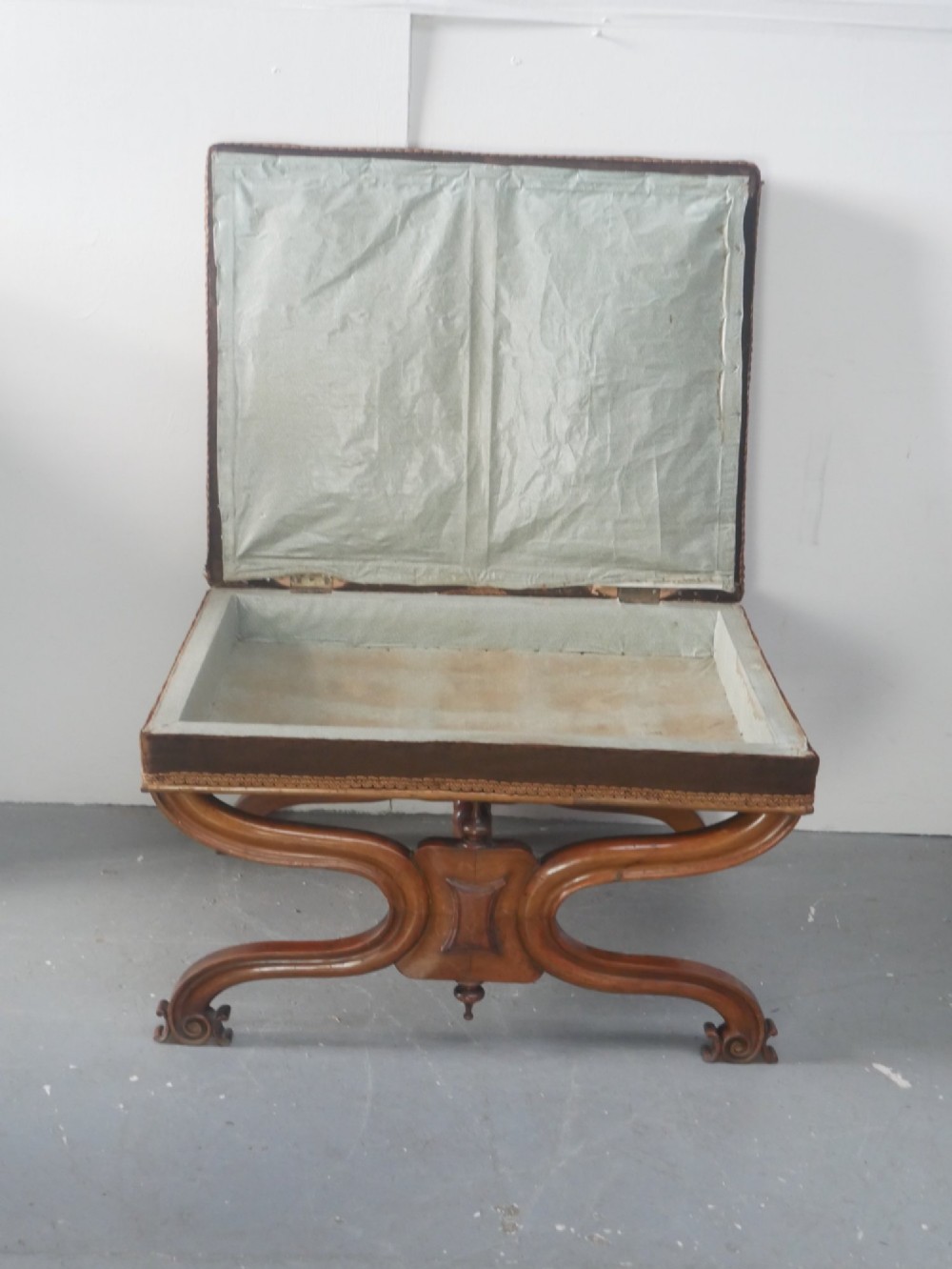 An antique Scottish Baronial X-frame stool crafted from carved wood with scrolled feet, turned finials, and a brown velvet seat with floral tapestry top. View V