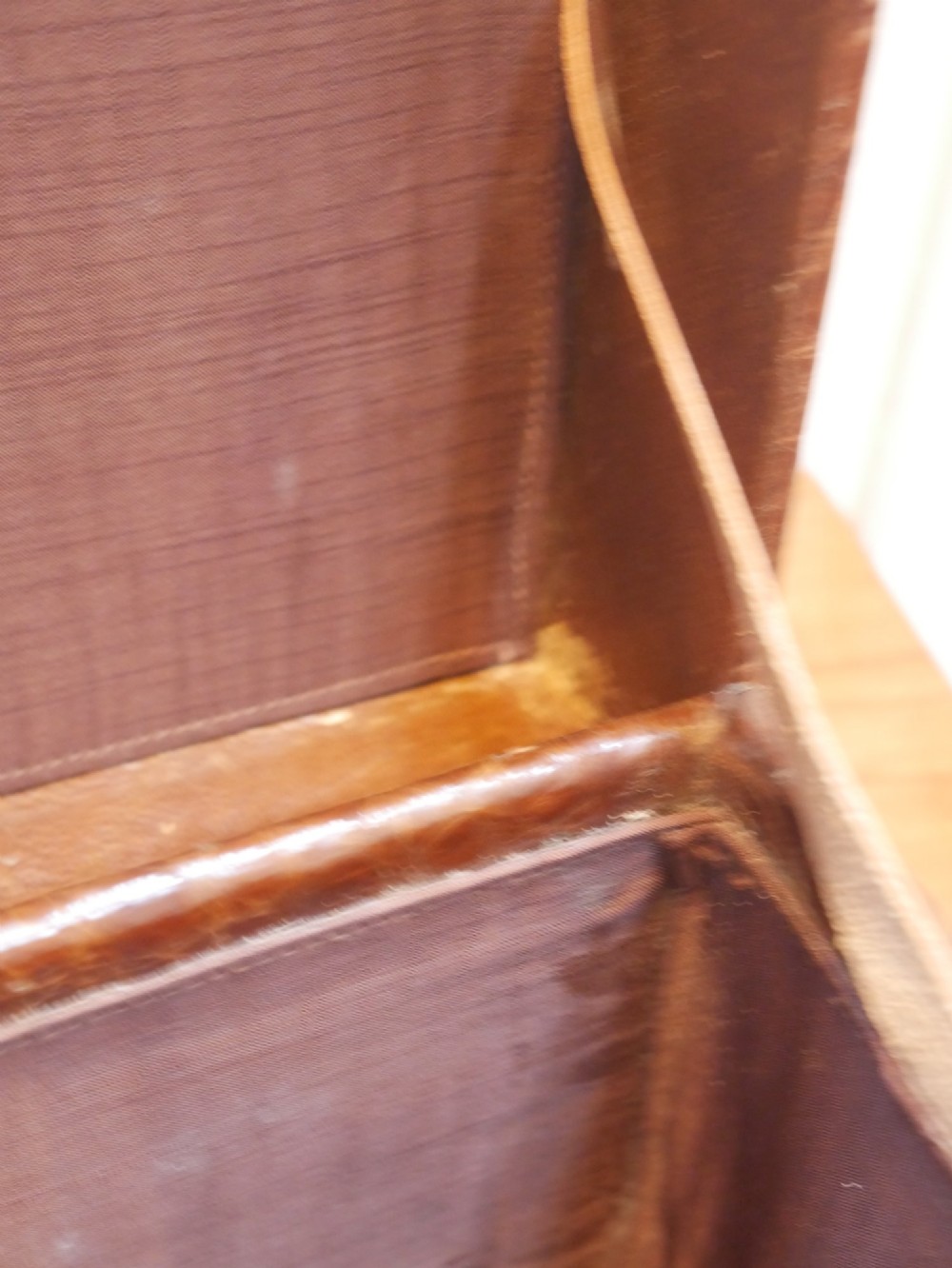 A small warm brown crocodile skin suitcase with brass locks and a stitched leather handle. View IV