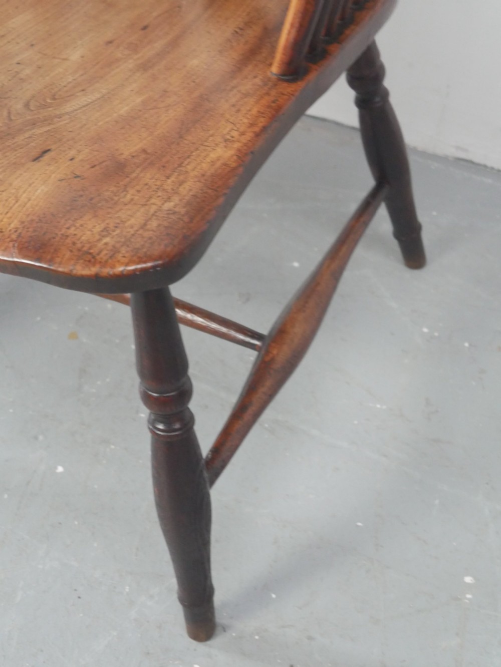 A warm brown antique Windsor armchair featuring a high back with a pierced wheelback splat, curved arms, and turned wooden legs. View VIII