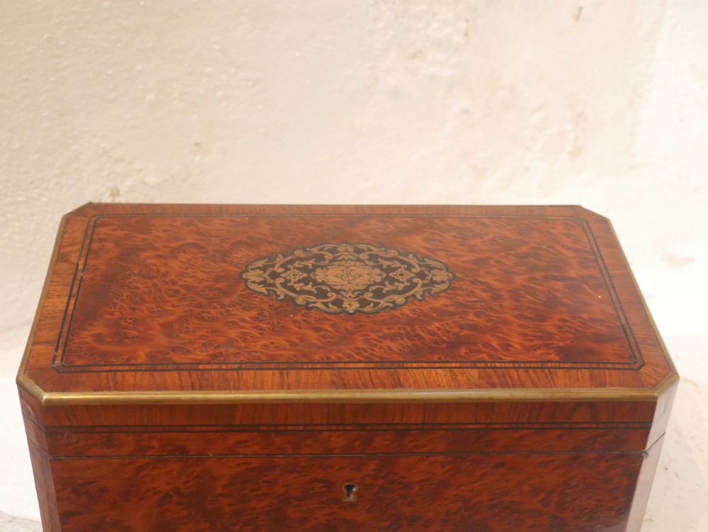 A 19th-century French amboyna wood box featuring canted corners, brass edging, and central brass inlay on the lid. View II