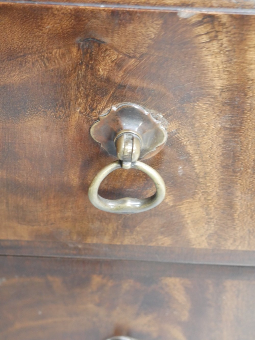 A wide Scottish flame mahogany chest of drawers featuring top diamond-inlaid frieze drawers, brass drop handles, and turned feet. View III