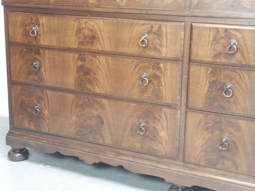 A wide Scottish flame mahogany chest of drawers featuring top diamond-inlaid frieze drawers, brass drop handles, and turned feet. View IV