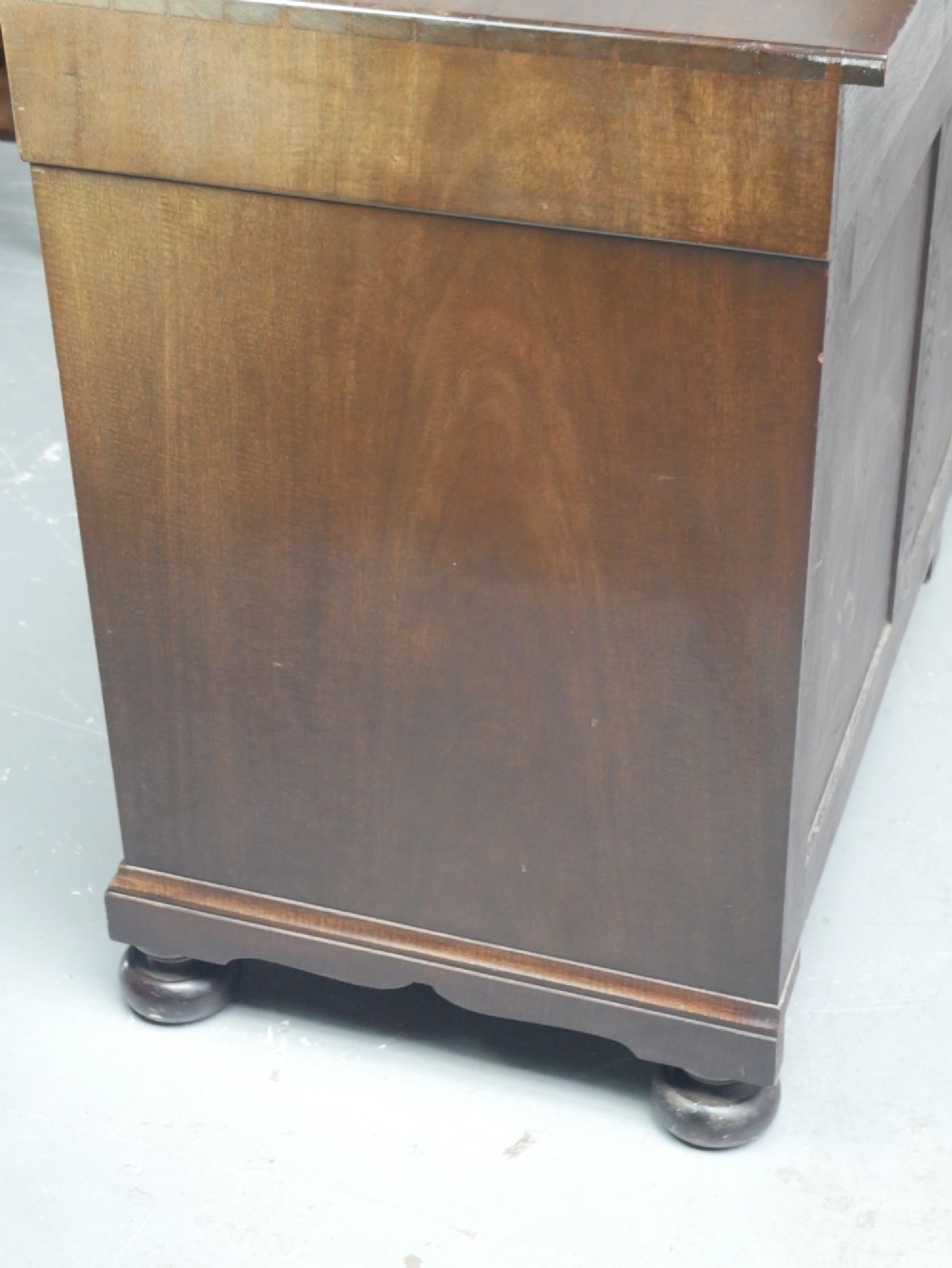 A wide Scottish flame mahogany chest of drawers featuring top diamond-inlaid frieze drawers, brass drop handles, and turned feet. View VIII